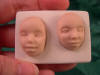 two doll faces in a mold