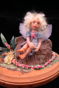 Baby Fairy Angel sitting on a rock in a garden patch