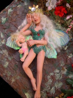Dollhouse fairy mother and child sleeping in a garden patch
