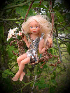 girl fairy doll in tree swing