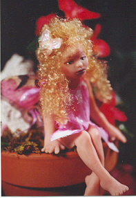 Girl Fairy sitting on the edge of a potted plant